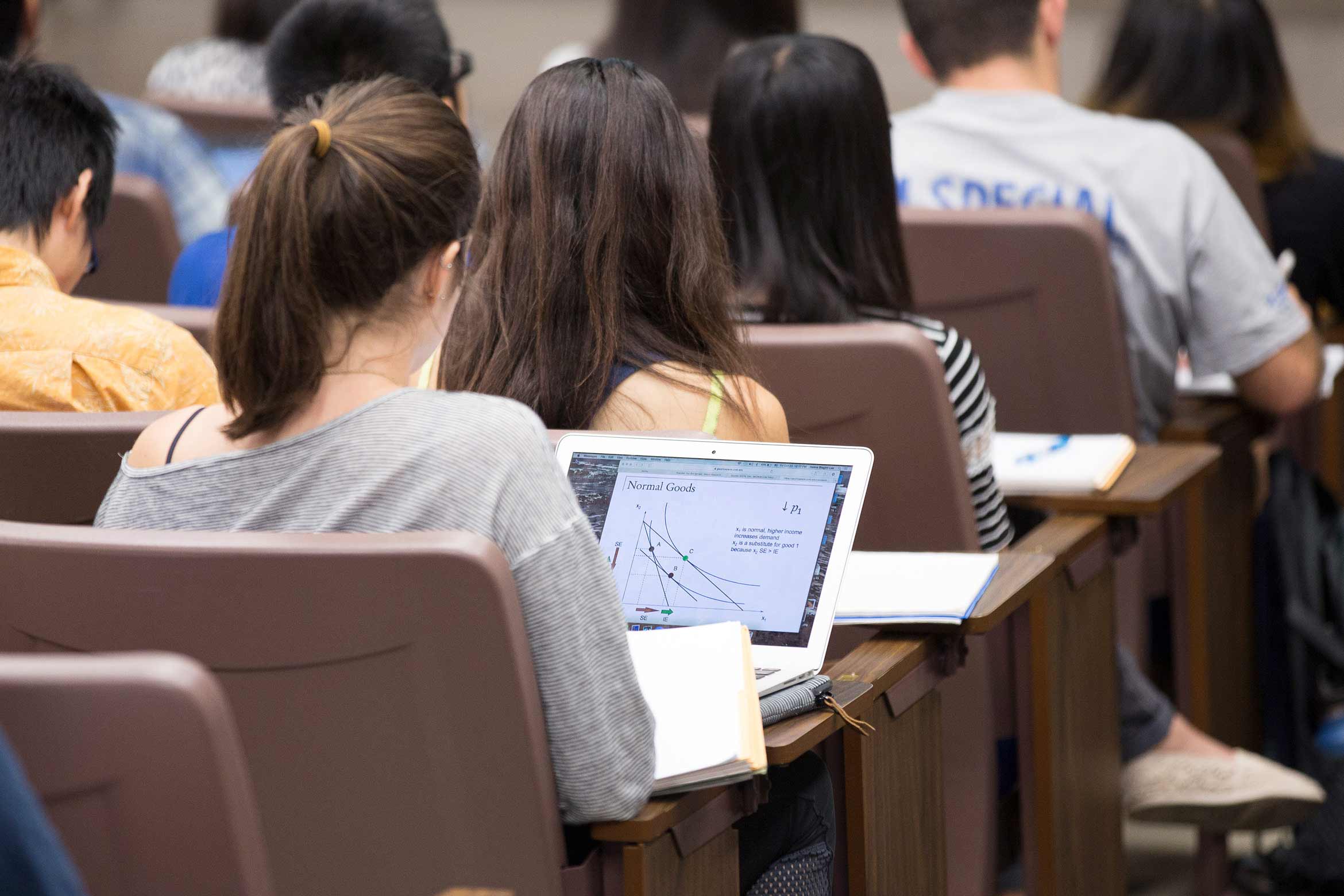 a classroom full of students busy taking notes.