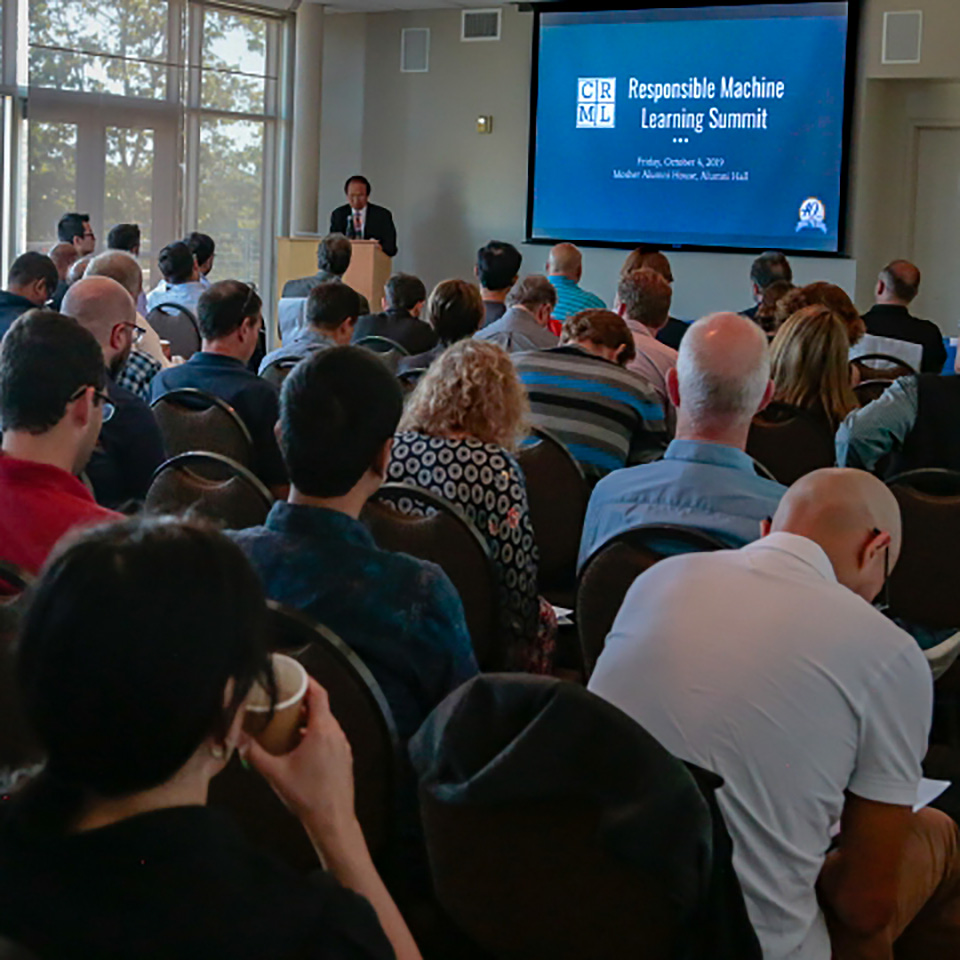 Conference room full of attendees with Henry T. Yang speaking.